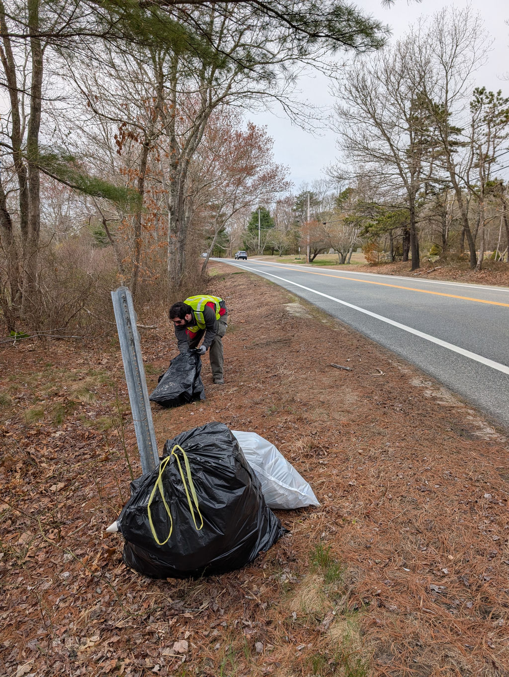 Douglas places trash in a bag on the side of Rt. 138